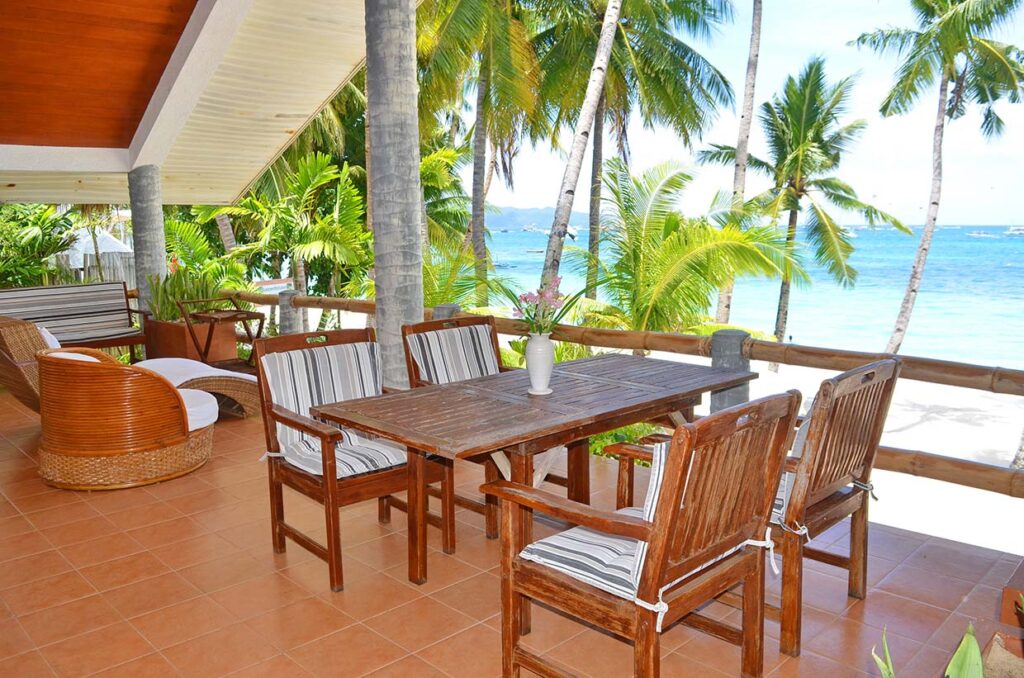 Sea-view balcony with dining table under the palms