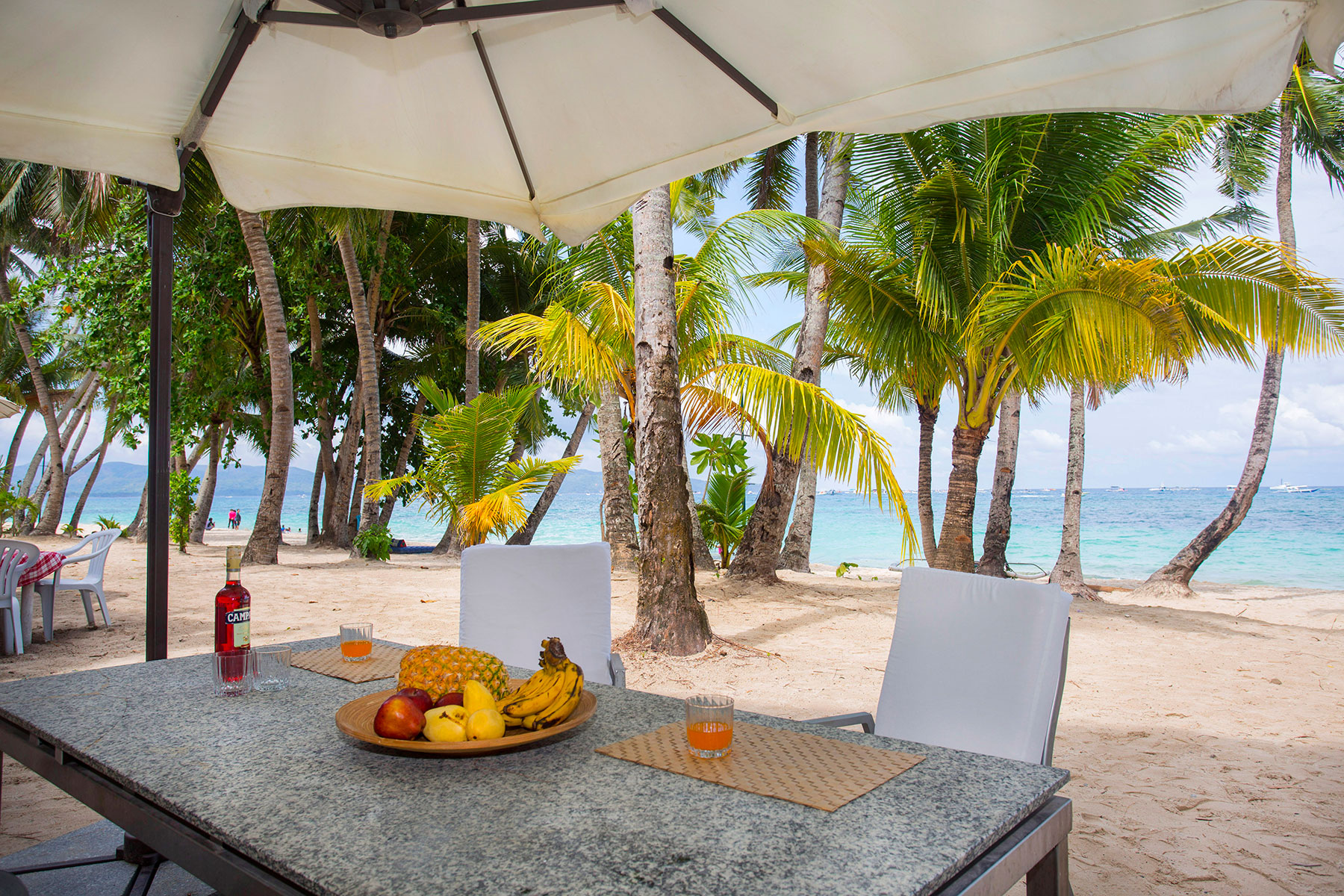 Breakfast table under a parasol on the beach